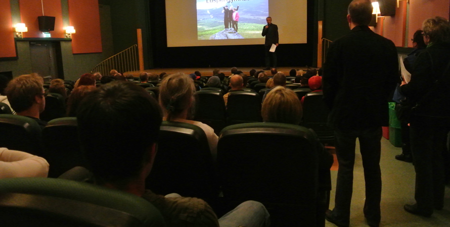 fullsatt biosalong med talare på scen