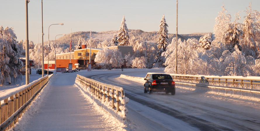 Bil kör över en snöig bro