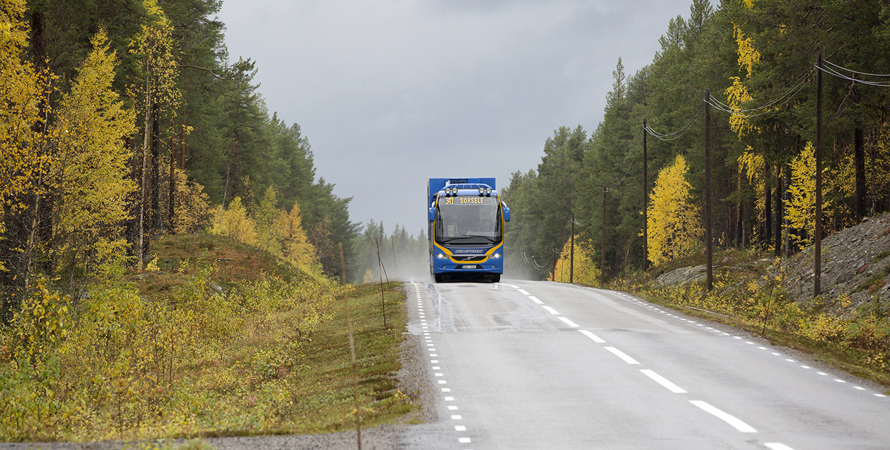 En blå buss med texten 31 Sorsele kör på en höstig landsväg