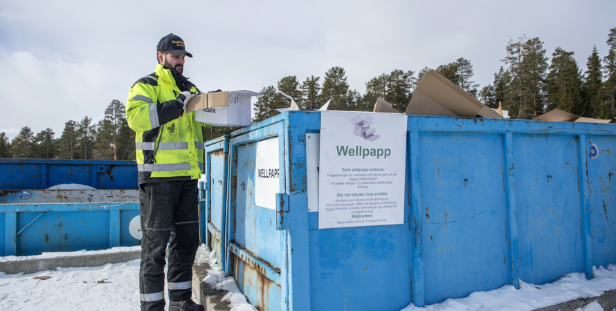 En man står invid en blå container 