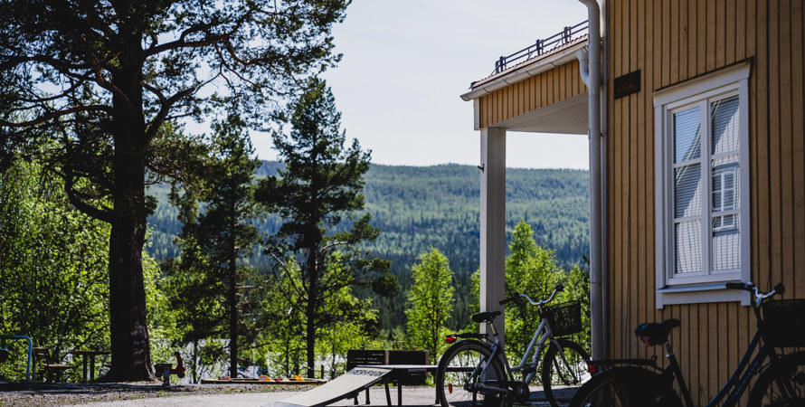 Hörnet på en gul byggnad. Utanför står det cyklar.