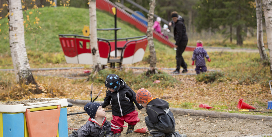 Barn leker i en sandlåda.